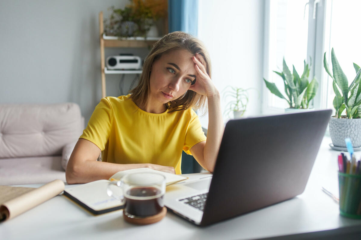 Emotional gestresste Frau sitzt vor einem Laptop © Ekaterina Goncharova / Getty Images